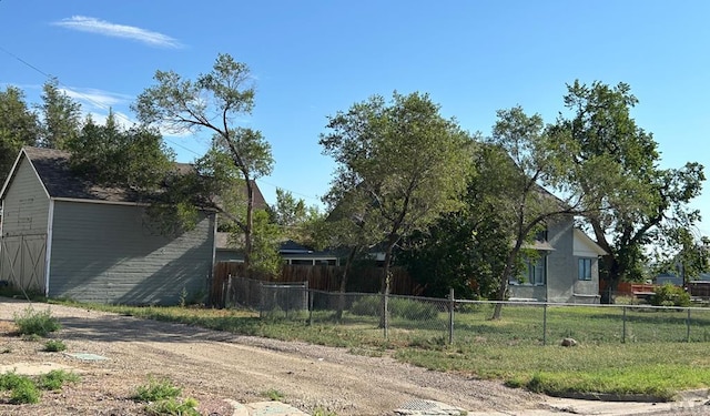 view of side of home featuring fence, an outdoor structure, and a shed