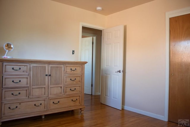 bedroom with wood finished floors and baseboards