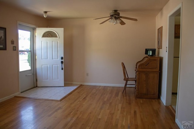 entryway featuring light wood-type flooring, baseboards, and a ceiling fan