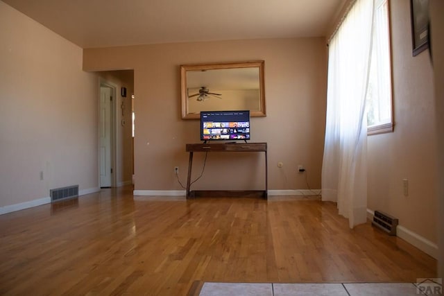 interior space with light wood finished floors, visible vents, and baseboards