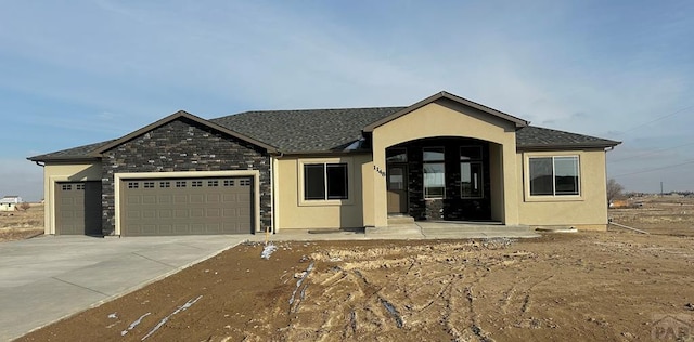 single story home with a garage, driveway, and stucco siding