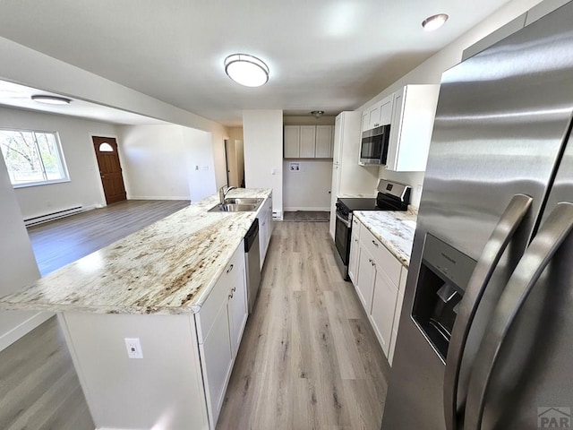 802 E 5th St, Florence, CO 81226 - kitchen featuring white cabinets, appliances with stainless steel finishes, light wood finished floors, and a sink