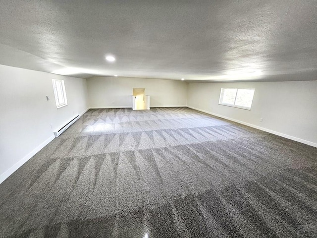 802 E 5th St, Florence, CO 81226 - basement with a baseboard heating unit, a textured ceiling, carpet floors, and baseboards