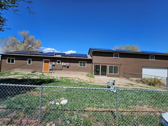 802 E 5th St, Florence, CO 81226 - back of house featuring roof mounted solar panels and a fenced backyard