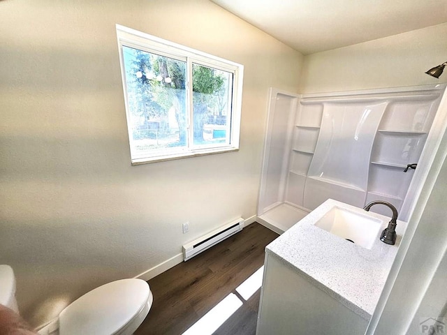 802 E 5th St, Florence, CO 81226 - bathroom featuring vanity, a shower, baseboards, wood finished floors, and a baseboard radiator