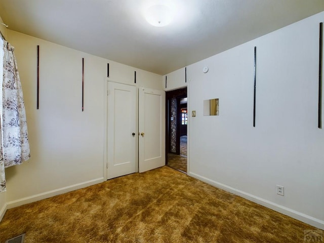 unfurnished bedroom with carpet, a closet, visible vents, and baseboards