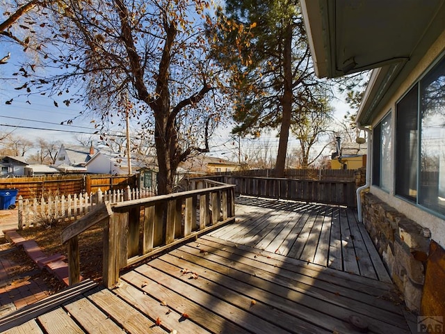 wooden terrace with a fenced backyard