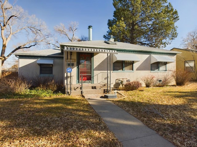 bungalow-style house with crawl space, a front lawn, and stucco siding