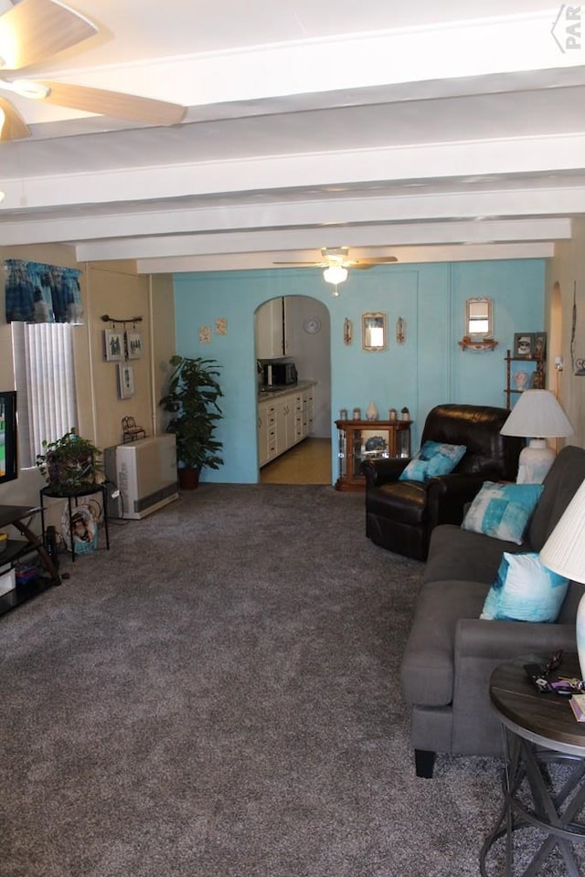 carpeted living area featuring ceiling fan and beam ceiling