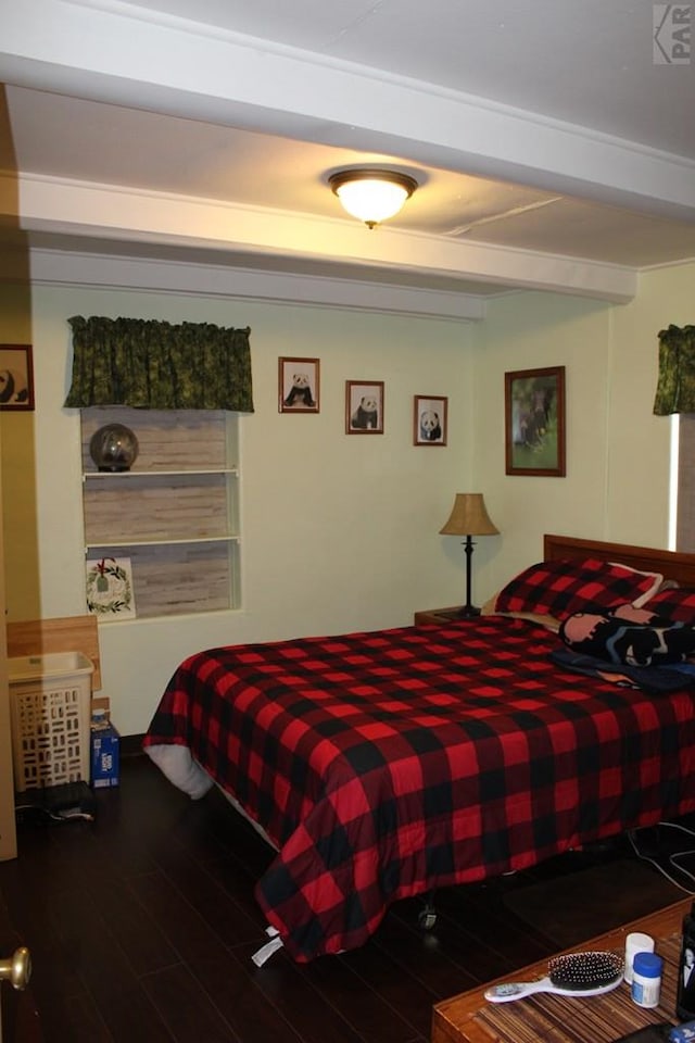 bedroom featuring dark wood-style floors and beam ceiling