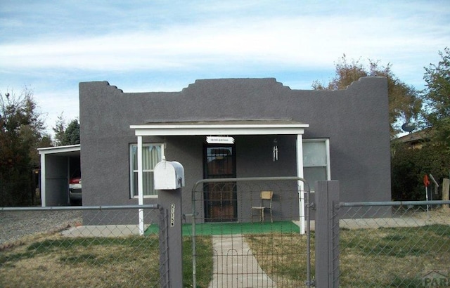 view of front of property featuring a fenced front yard, a gate, and stucco siding