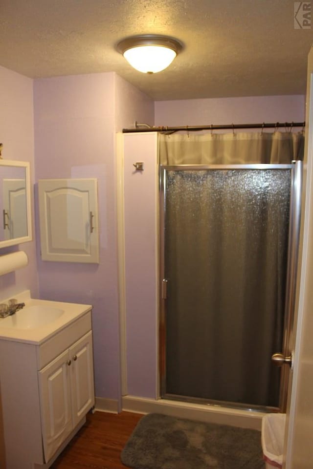 bathroom featuring curtained shower, vanity, a textured ceiling, and wood finished floors