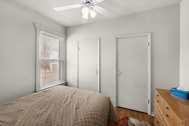 bedroom with a ceiling fan and wood finished floors