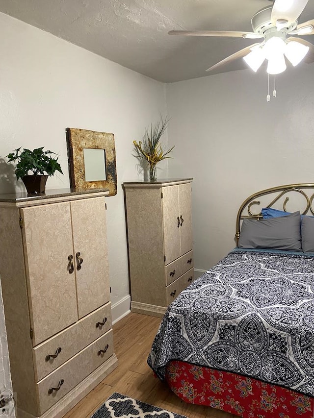 bedroom with baseboards, light wood-type flooring, and a ceiling fan