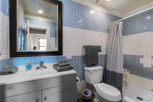 full bath featuring a shower stall, toilet, vanity, and tile walls