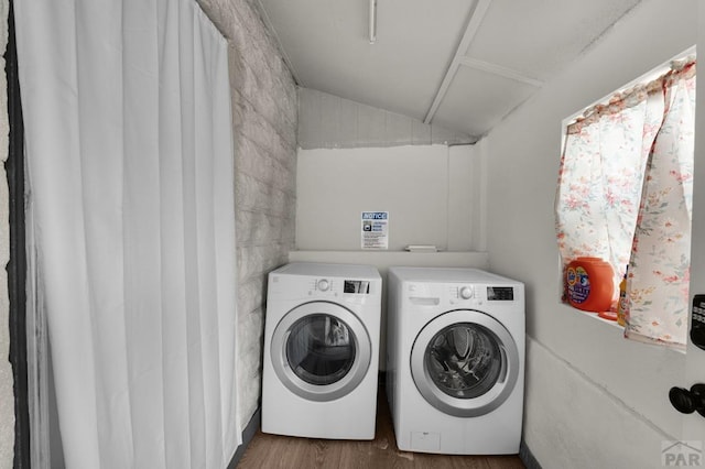 laundry room with washing machine and clothes dryer and wood finished floors