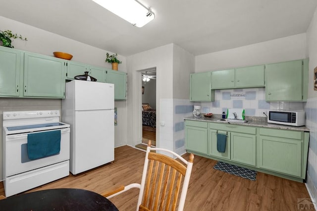 kitchen featuring green cabinets, white appliances, and light wood-style floors
