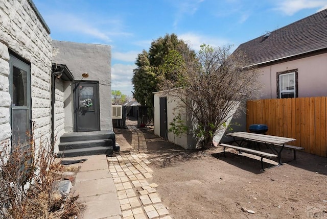 view of yard with a patio area, fence, and an outbuilding