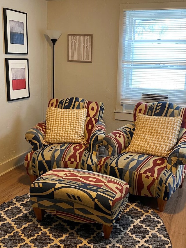 sitting room with baseboards and wood finished floors