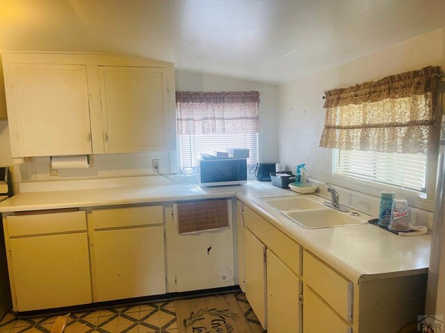 kitchen with light countertops, light floors, and a sink