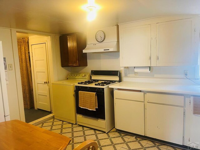 kitchen featuring white cabinetry, range with gas stovetop, light countertops, light floors, and washer / dryer