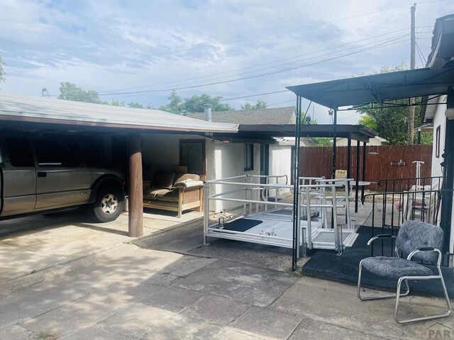 exterior space with a carport and fence