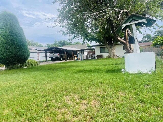 view of yard with a carport and fence