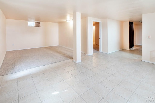 interior space featuring light tile patterned flooring, light colored carpet, and baseboards