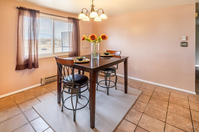 dining space featuring baseboards, a baseboard heating unit, and an inviting chandelier