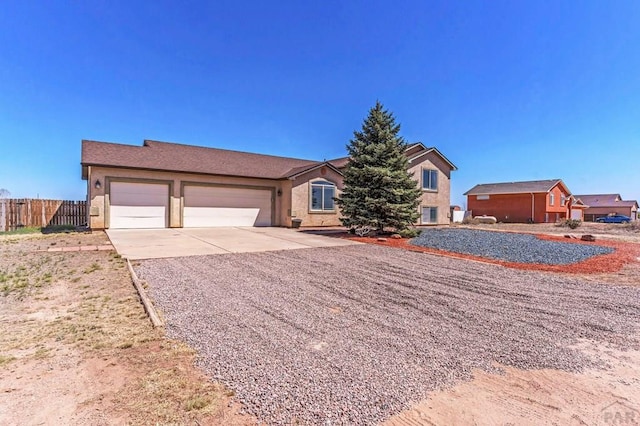 ranch-style house featuring a garage, stucco siding, driveway, and fence