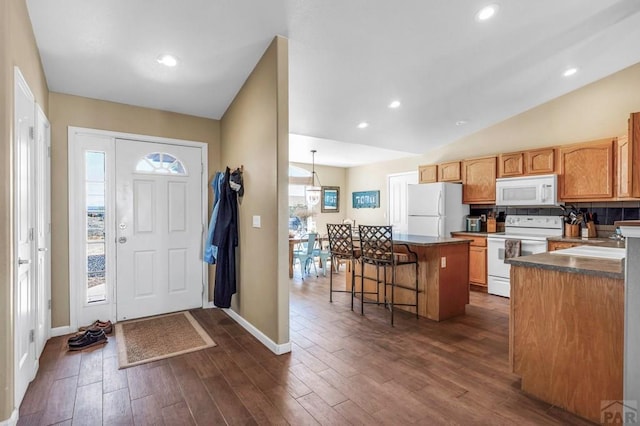 foyer with recessed lighting, vaulted ceiling, baseboards, and dark wood-style floors
