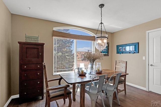 dining room with wood-type flooring, baseboards, and an inviting chandelier