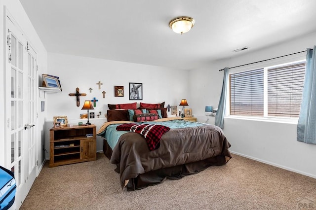 carpeted bedroom featuring baseboards and visible vents