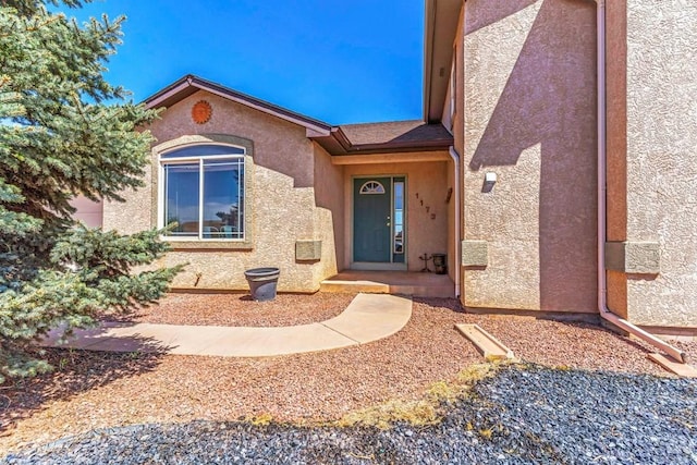 entrance to property featuring stucco siding
