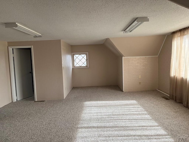 bonus room with carpet and a textured ceiling