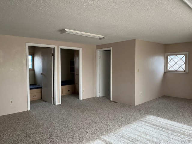 spare room with a textured ceiling and carpet floors