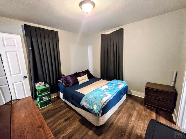 bedroom featuring dark wood-type flooring and baseboards