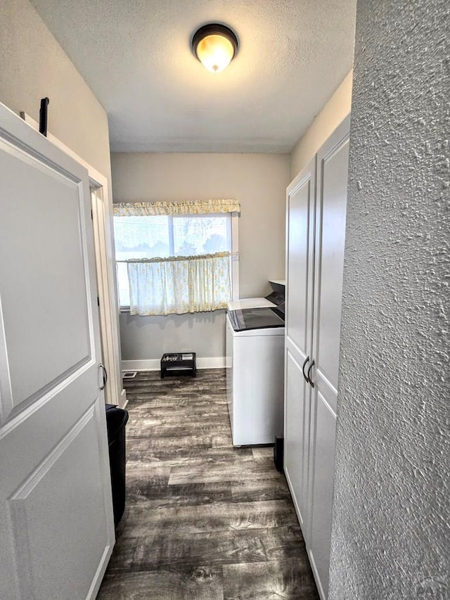 washroom featuring dark wood-style floors, washer / clothes dryer, a textured ceiling, laundry area, and baseboards