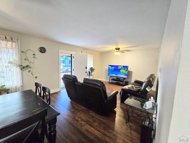 living area featuring ceiling fan, baseboards, and dark wood finished floors