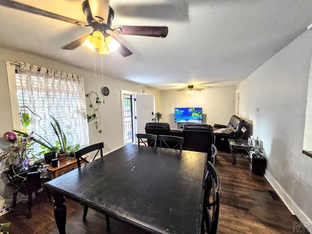 dining room featuring dark wood-style floors, visible vents, baseboards, and a ceiling fan