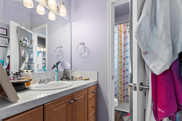 full bathroom featuring toilet, a shower with curtain, wood finished floors, and vanity