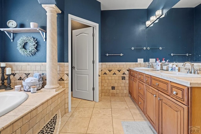 full bath featuring tile patterned flooring, a sink, and decorative columns