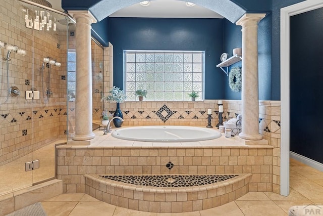 bathroom with ornate columns, a shower stall, and tile patterned floors