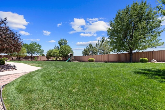 view of yard featuring a fenced backyard and a playground