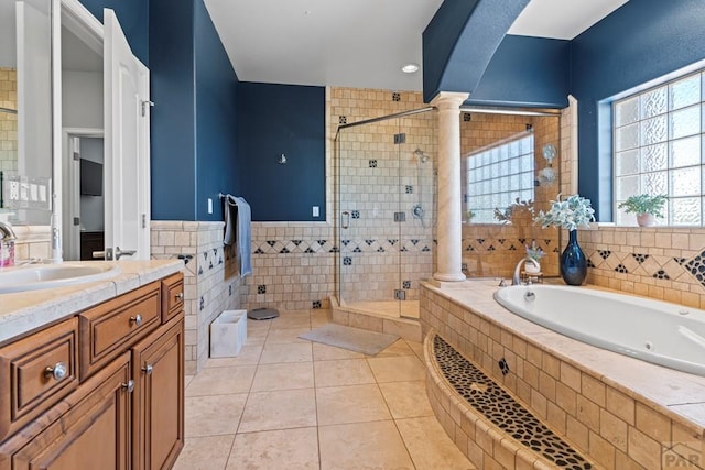 bathroom with a garden tub, decorative columns, tile walls, a shower stall, and tile patterned flooring