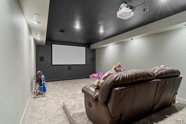 carpeted home theater room with visible vents and baseboards