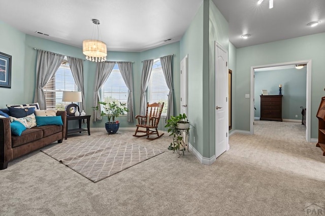 living area featuring baseboards, visible vents, and light colored carpet