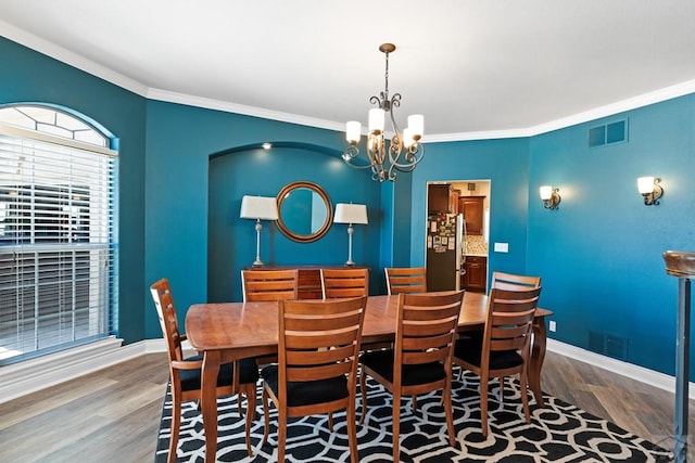 dining area with baseboards, visible vents, and wood finished floors