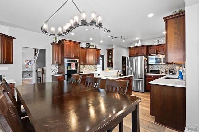 dining area featuring recessed lighting, a notable chandelier, and light wood-style flooring