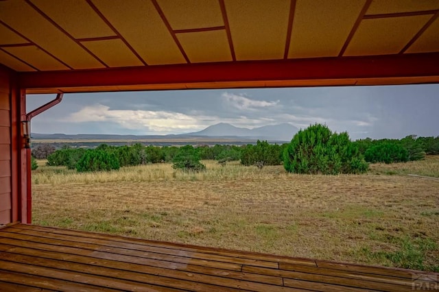 wooden terrace with a rural view and a mountain view
